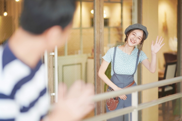 男性を見送って手を振る女性