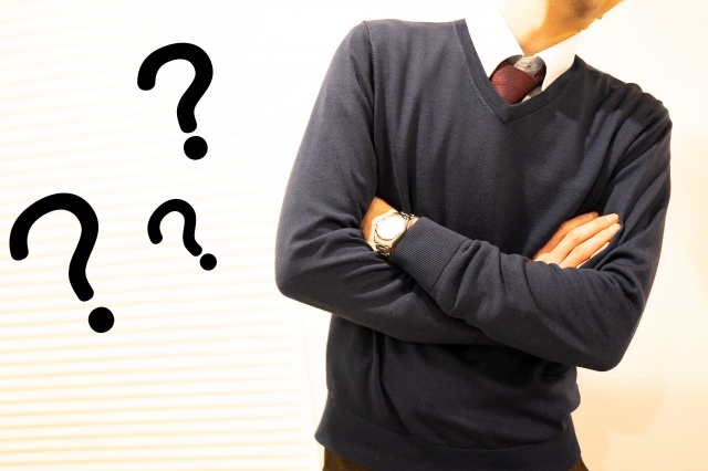 腕を組んで考え込んでいる男性の写真。そばに大きなクエスチョンマークが浮かんでおり、混乱や迷いを表している。